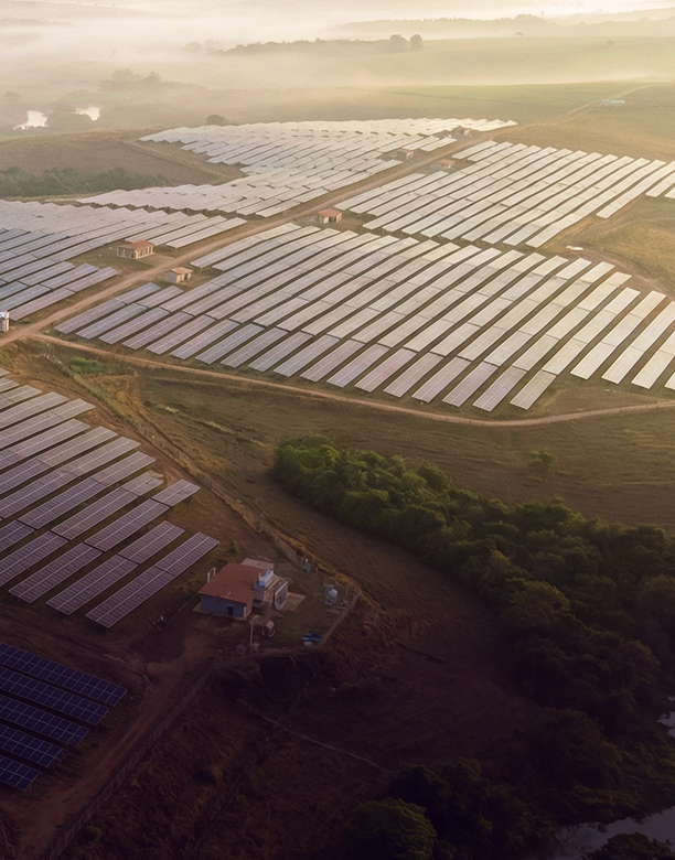 Vista aérea de usina solar de grande porte ao pôr do sol