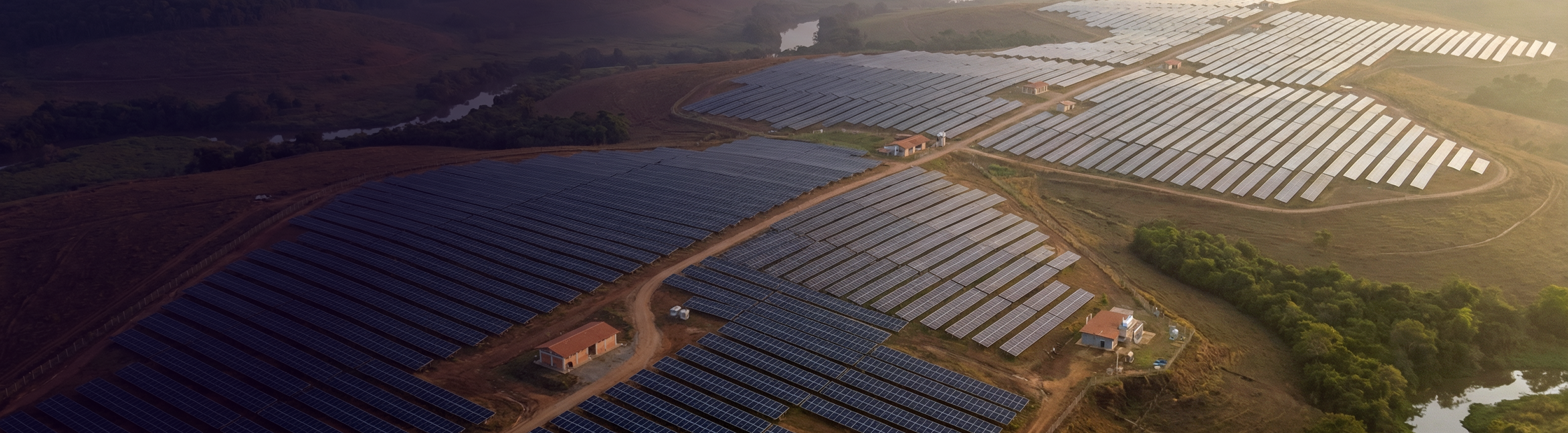 Vista aérea de usina solar com centenas de painéis fotovoltaicos ao pôr do sol